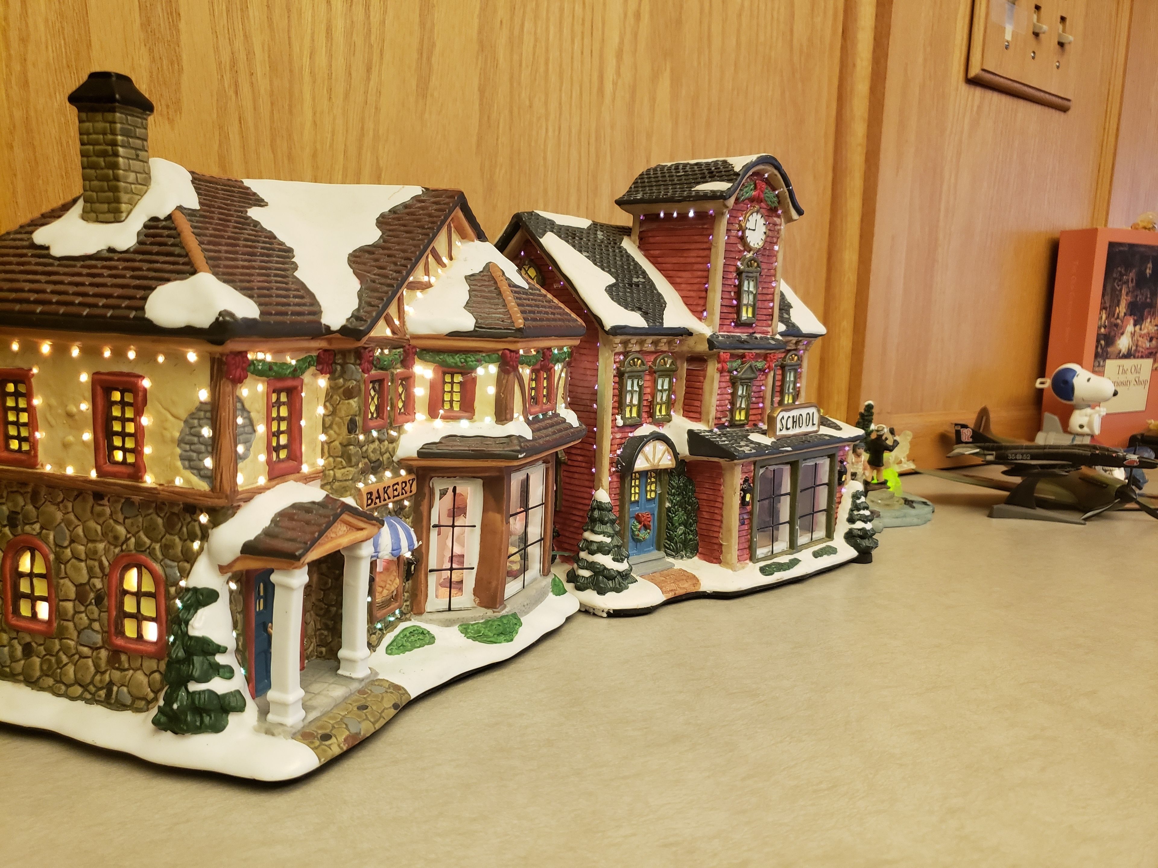 Une maquette d’un village enneigé comprenant une boulangerie, une école et une église.
