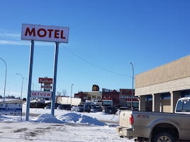 Señal de motel con vista despejada de los alrededores, incluyendo un Tim Hortons y una señal de SkyView.