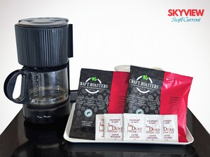 A coffee maker, coffee pods, and a coffee grinder on a table.