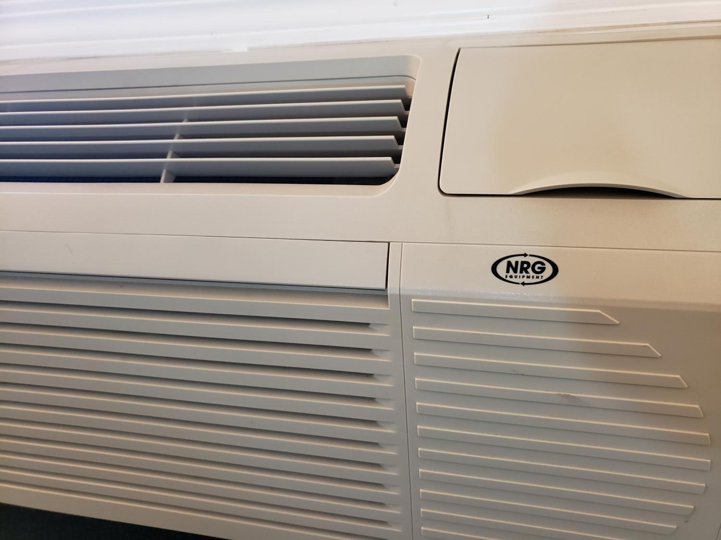 A white air conditioning unit with horizontal slats and a logo that reads 'NRG EQUIPMENT'.
