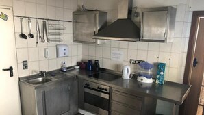 A compact kitchen with stainless steel appliances, a sink, and a stove. - Pension Lume (Oberraden)