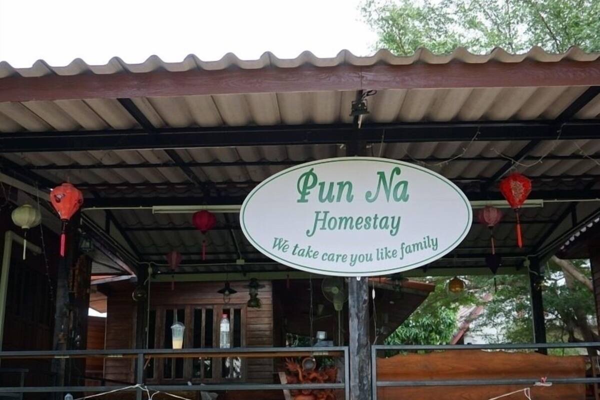 A sign for 'Pun Na Homestay' with a message 'We take care you like family'.