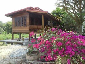 A wooden cabin with a porch, a bench, and a dog. - Pun Na Homestay Bangsai (Bang Sai)