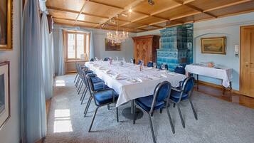 A conference room with a long table, blue chairs, and a chandelier.