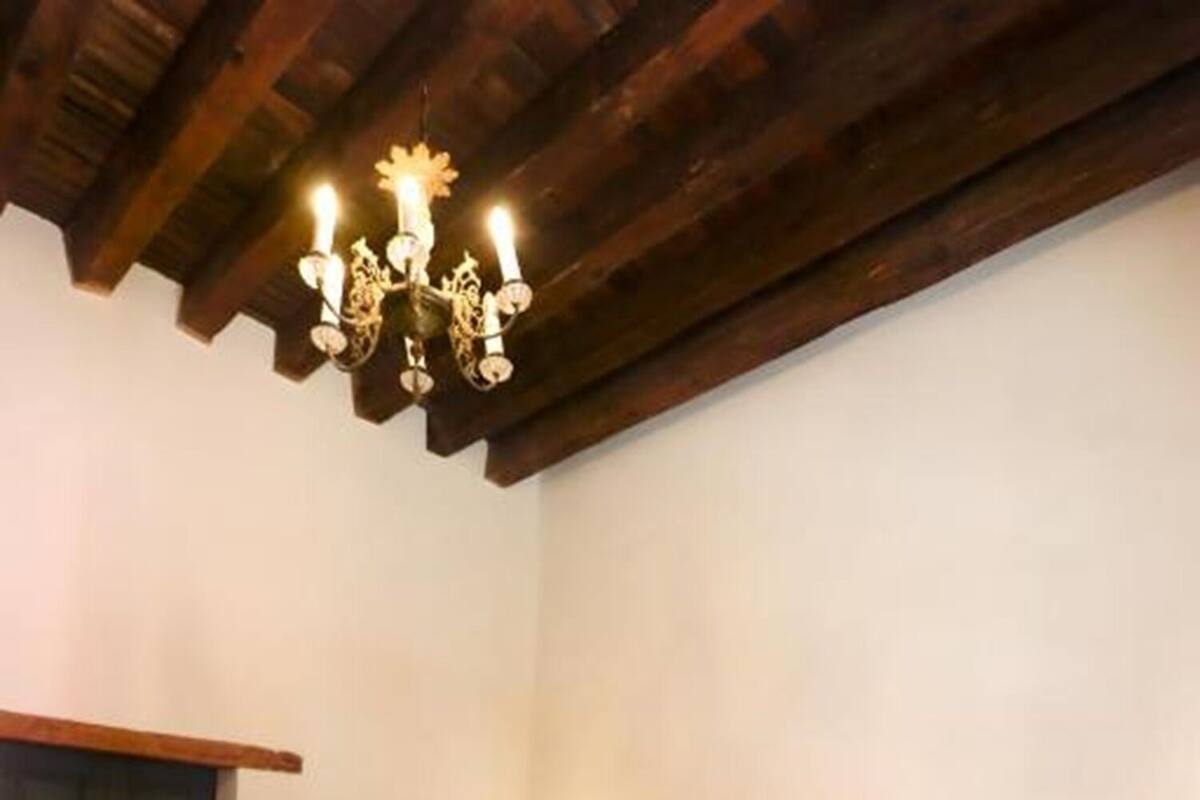 Une chambre à coucher avec un lit en bois, un lustre et une table de chevet.
