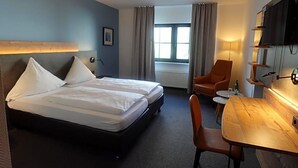 A hotel room with two beds, a desk, a chair, a TV, and a window with curtains. - Hotel Weinhaus Zum Schwarzen Bv Ren (Koblenz)