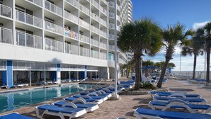 A hotel with a pool area, sun loungers, and a building with balconies. - Amazing Luxury Direct Ocean Front 1BD/1BA,  Modern Decor. Great Location! (Myrtle Beach)