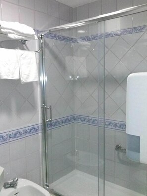 A bathroom with a glass shower enclosure, a sink, and a towel rack. - LOS Helechos (Sanlucar de Barrameda)