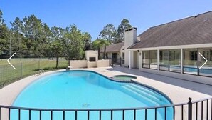 Une maison moderne dotée d’une piscine, d’un patio couvert et d’une cour clôturée.