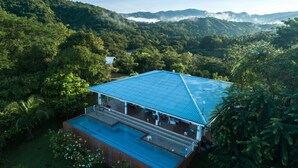 A resort with a large pool and a covered outdoor area, surrounded by lush greenery and mountains. - Torio guesthouse with panoramic view- Kokomo (Torio)