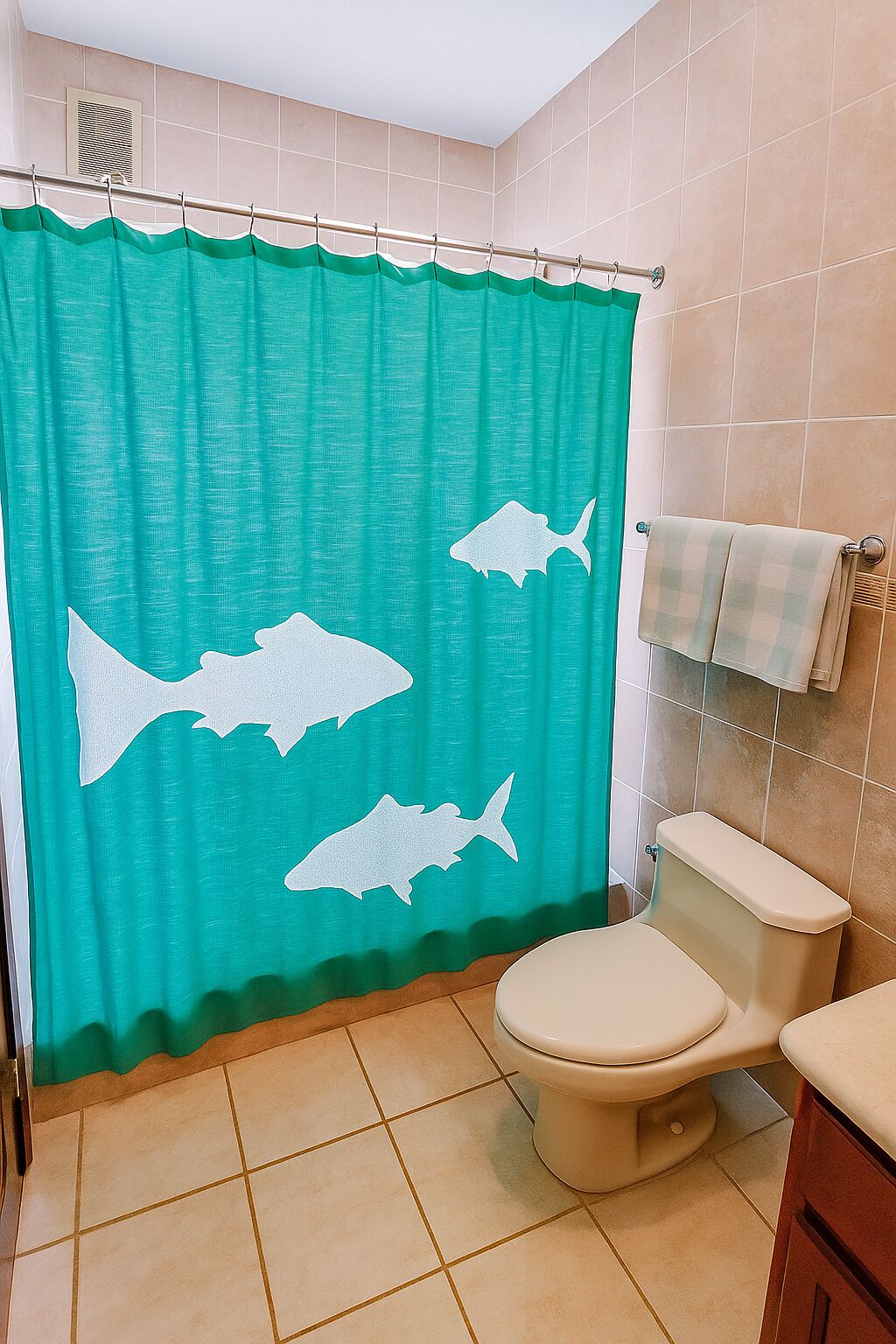 Une salle de bain avec un rideau de douche orné de silhouettes de requins, des toilettes et un porte-serviettes.