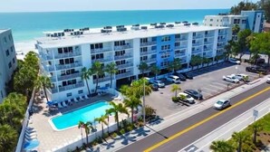 A multi-story hotel with a pool, parking lot, and ocean view. - Award Winning Direct Gulf Front Condo with a Fantastic Sunset View (Indian Shores)