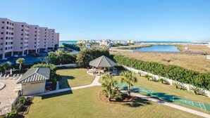 Un resort con piscina, un pabellón y vista al océano.