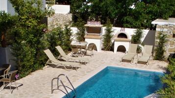 Een buitenzwembad, parasols voor strand/zwembad