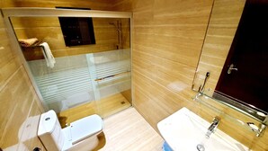 Une salle de bain moderne avec une douche à parois de verre, des toilettes et un lavabo avec un miroir.