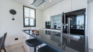 Una cocina moderna con una isla central, electrodomésticos de acero inoxidable y un diseño minimalista.