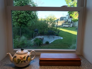 Enjoy a serene view of the beautifully maintained outdoor space with a lawn, patio, and barbecue grill.