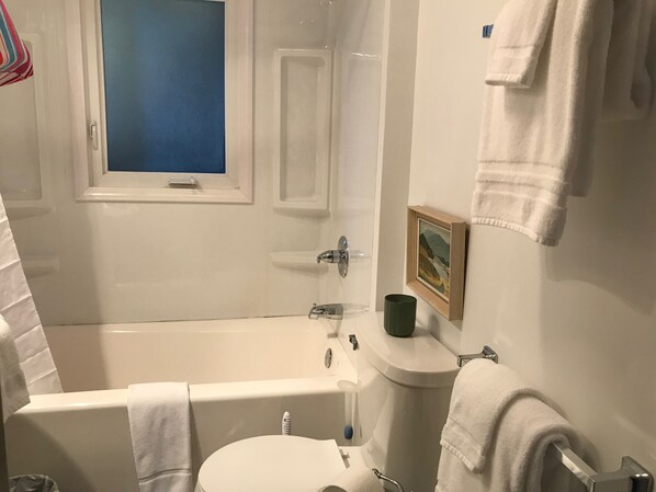 A bathroom with a bathtub, toilet, and sink.