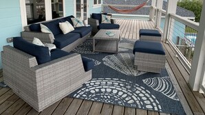 Un espace extérieur aménagé avec des meubles en osier, un hamac et une vue sur une piscine.