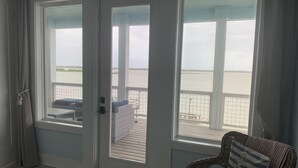 Une chambre avec vue sur la plage, accessible par une porte vitrée.