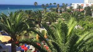 A beachside view with palm trees, outdoor seating, and a view of the ocean. - Location, location, location! Front line beach with all Nerja amenities to hand. (Nerja)