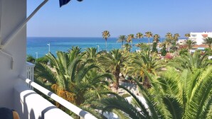 A balcony with a view of the sea, palm trees, and a building in the background. - Location, location, location! Front line beach with all Nerja amenities to hand. (Nerja)