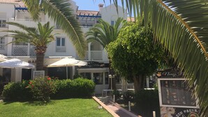 A courtyard with palm trees, a restaurant named 'Cruzcampo', and a sign for 'Fresh Pasta & Much More'. - Location, location, location! Front line beach with all Nerja amenities to hand. (Nerja)