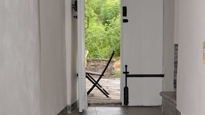 Un couloir avec une porte blanche donnant sur un balcon.