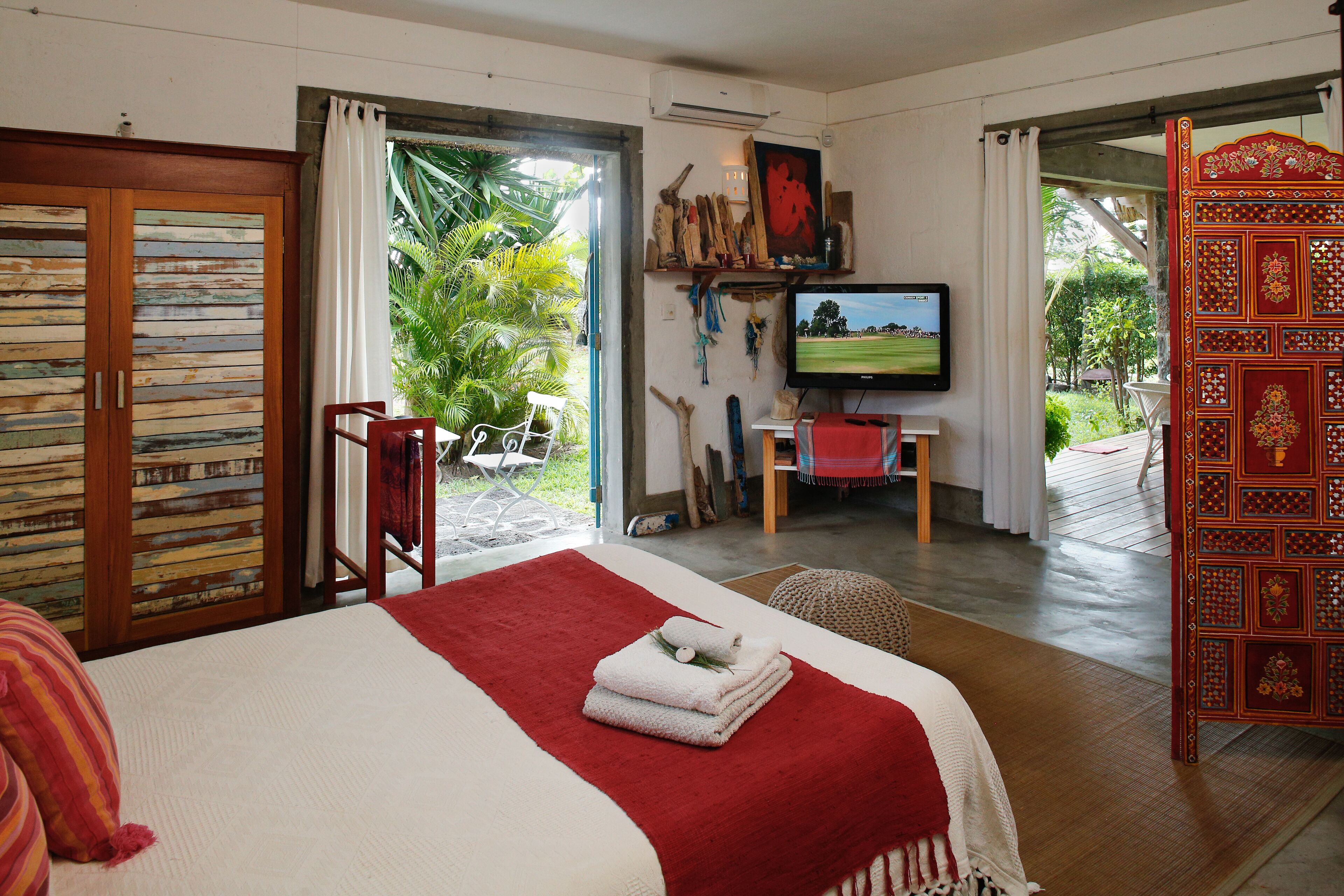 Een slaapkamer met een bed, een televisie en uitzicht op het omliggende landschap.