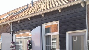 A house with a dark facade, a tiled roof, and a white door. - VRIJ van 29 augustus tot 5 september .2 pers studio 5 min lopen  het strand (Westkapelle)