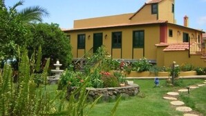A yellow building with a garden, a fountain, and a stone pathway. - Casa rural Villa Caya for 4 people (Orotava (La))