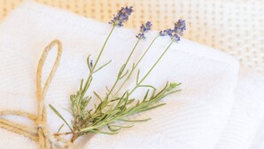 A white towel with a sprig of lavender and a piece of twine.
