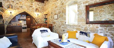 A cozy interior with stone walls, a dining area, and a kitchen.