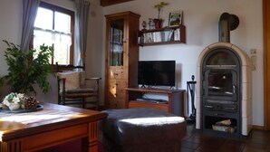 Una sala de estar acogedora con televisor, mueble de madera, estanterías y chimenea.