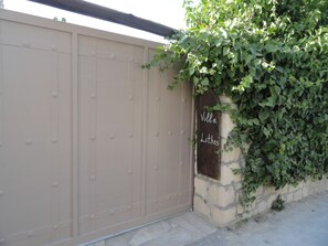 A beige gate with a sign that reads "Villa Litos." - Villa Lithos (Faistos)