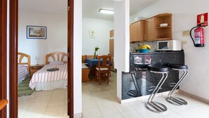 Un espace de vie compact comprenant une chambre, un coin repas et une kitchenette.