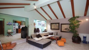 A spacious living area with a sectional sofa, a coffee table, and a potted plant.