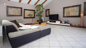 A modern living room with a sofa, TV, and artwork on the walls.