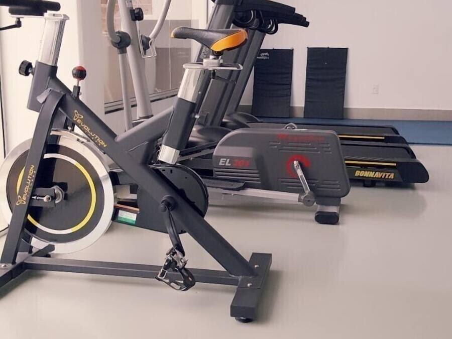 Uma academia com bicicletas ergométricas e elípticos.