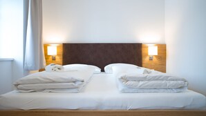 Un letto matrimoniale con lenzuola bianche e due abat-jour.