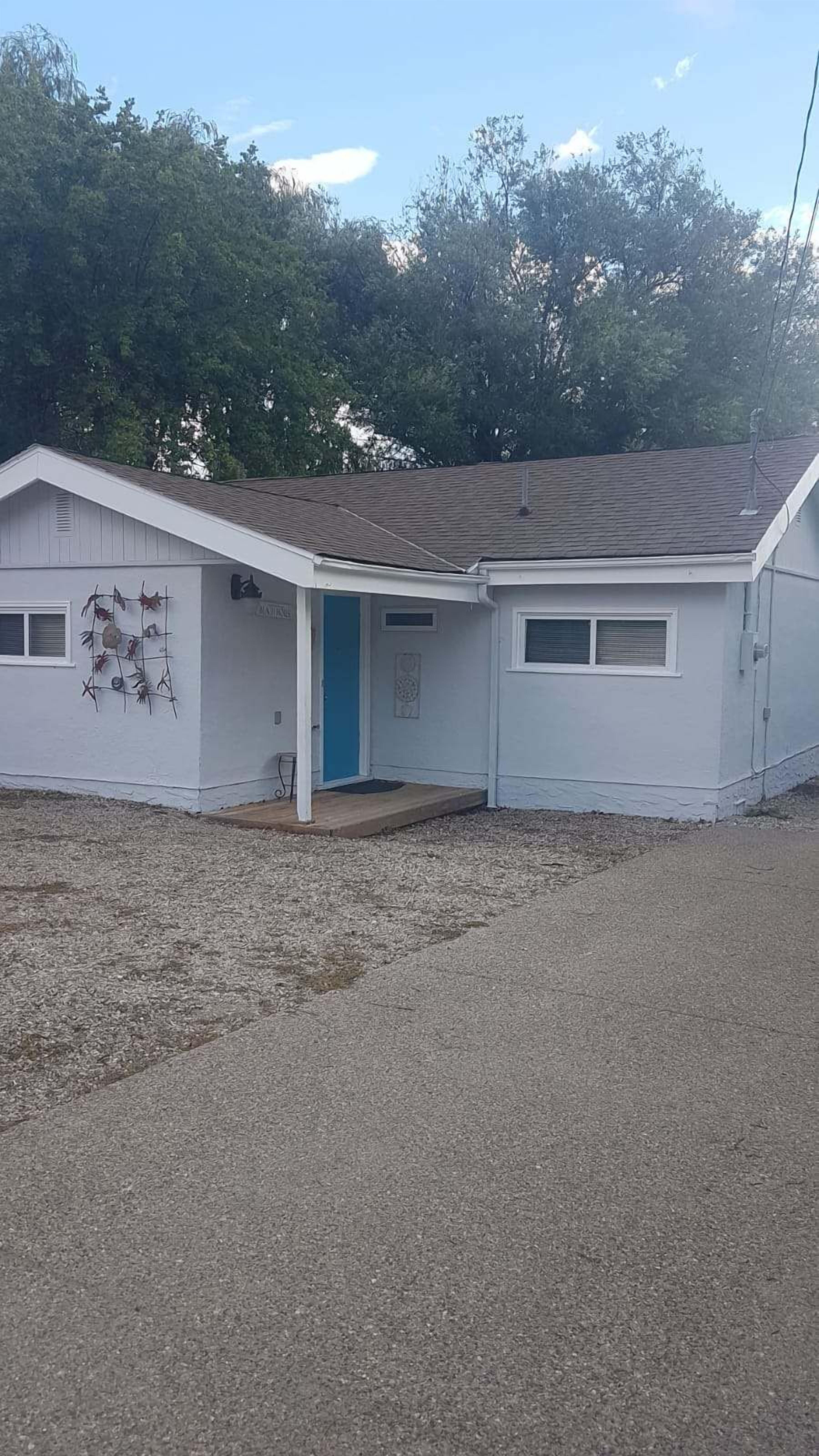 A single-story building with a blue door and a small porch.