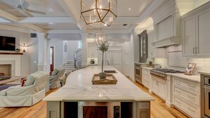 Una cocina moderna con una isla central, electrodomésticos de acero inoxidable y armarios blancos.