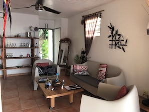 A living room with a sofa, coffee table, and shelves. - Charming Villa with Pool and Breathtaking View of the Caribbean Sea (Les Trois Ilets)