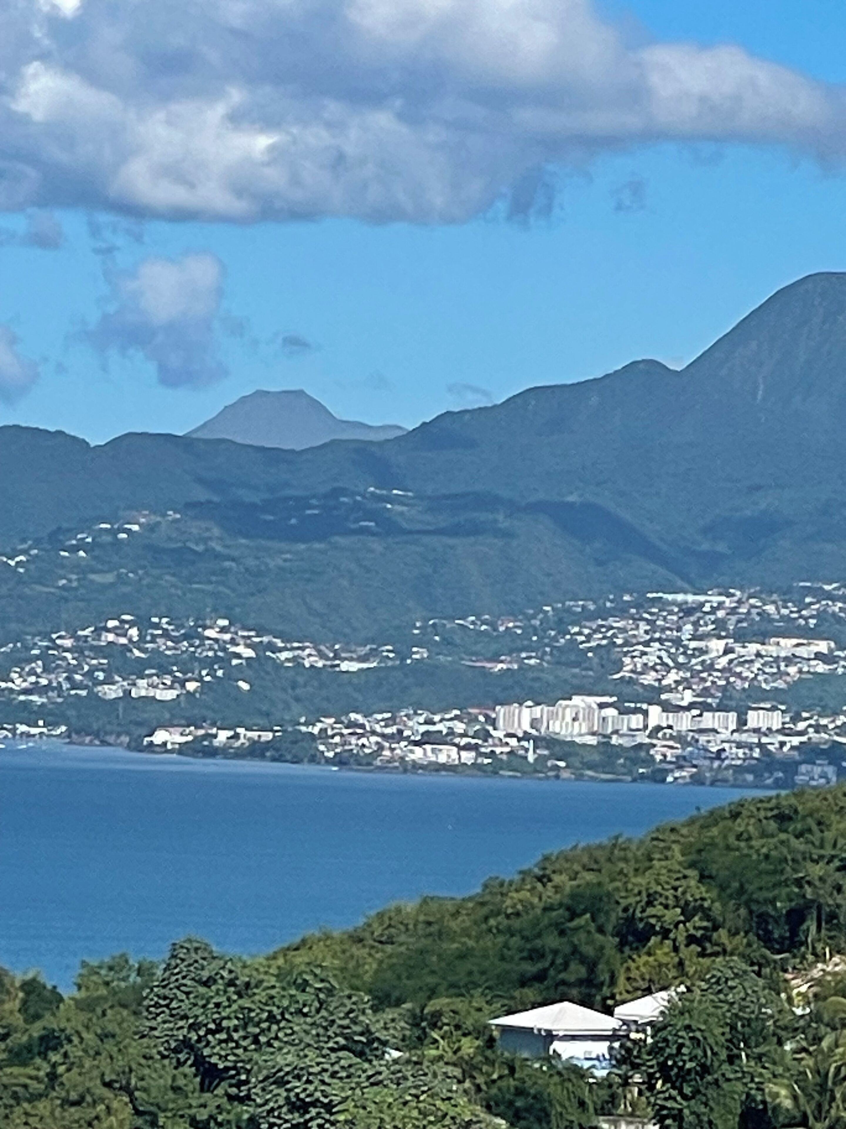 A coastal town with a view of the sea and mountains in the background.
