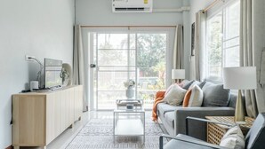 A modern living room with a sofa, coffee table, and a cabinet. - Discover Chiang Mai from Cheerful Contemporary Cottage (Muang Chiang mai)