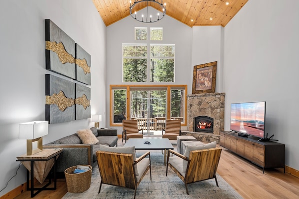 Un salón amplio con chimenea, ventanas grandes y una zona de estar acogedora.