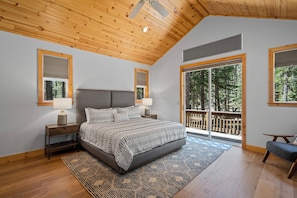 Un dormitorio con una cama grande, techo de madera y vistas a un balcón.