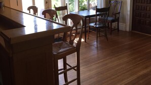 A kitchen with wooden cabinets, a central island, and a dining area with chairs and a table.