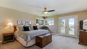 A bedroom with a bed, bedside tables, a dresser, a ceiling fan, and a view through the door. - Panoramic Views overlooking the Colorado River Valley (Grand Junction)