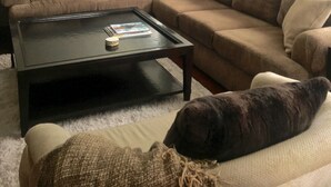 Ein Wohnzimmer mit einer großen Eckcouch, einem Couchtisch und einem großen Spiegel.